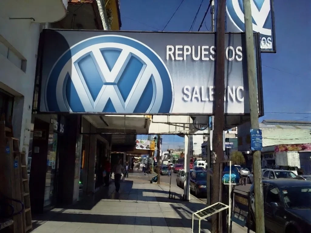 Entrada del local de VW Salerno vista desde la vereda de Av. Crovara 666, con el cartel de Repuestos Salerno sobre la galería